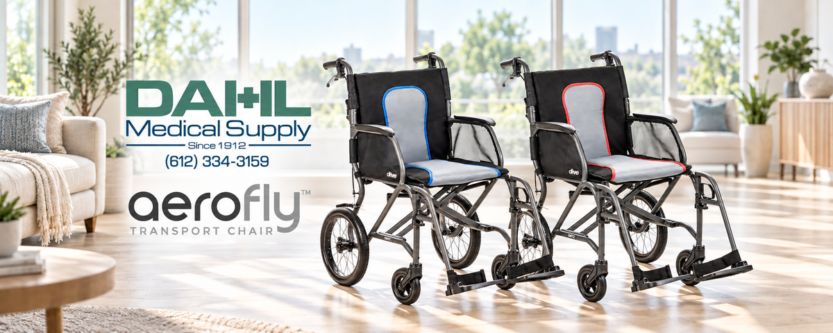 Gray and black AeroFly transport wheelchairs with blue and red upholstery trim in a sunlit room, beneath the Dahl Medical Supply and AeroFly logos.