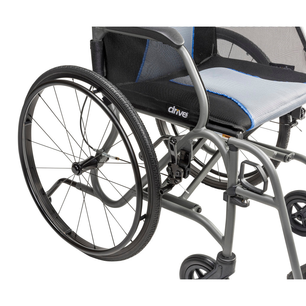 Close-up of the AeroFly wheelchair’s rear wheel, black armrest, gray frame, and gray seat upholstery with blue trim.