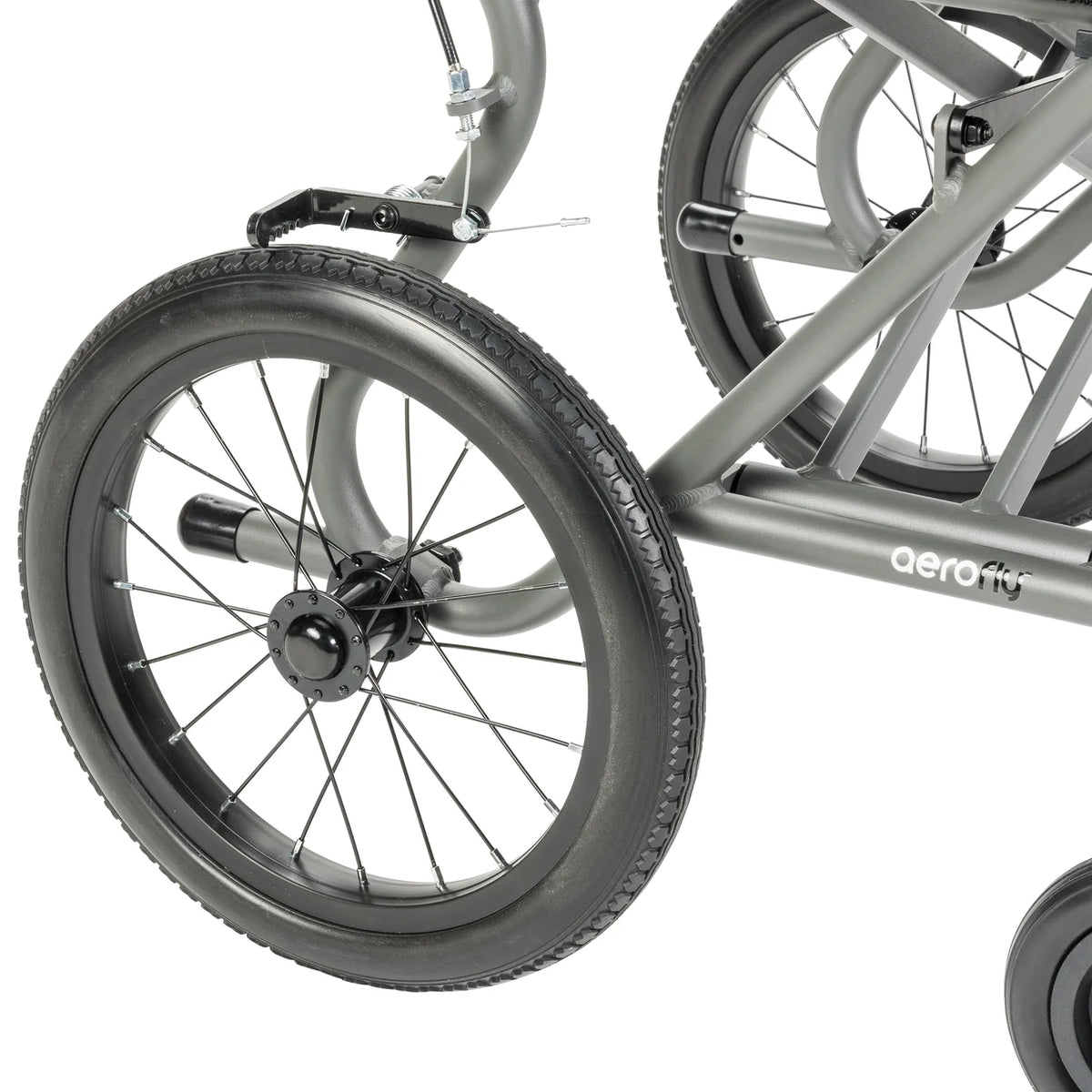 Close-up of the grey AeroFly transport wheelchair’s spoked rear wheel, brake assembly, and grey frame with AeroFly branding.