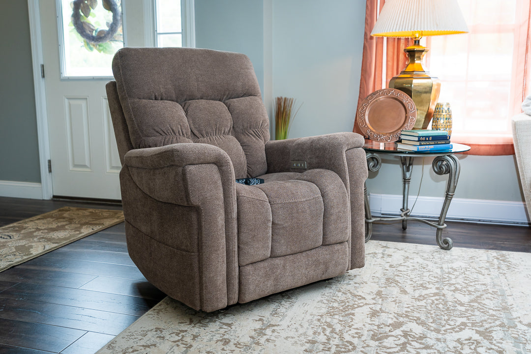 Pride PLR-4955 lift chair in Charcoal shown upright in a welcoming living room with soft fabric upholstery and plush cushioning.
