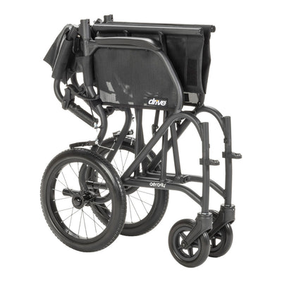 Black AeroFly transport wheelchair folded into a narrow profile with its wheels attached for transport and storage.
