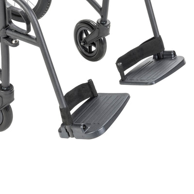 Close-up of the AeroFly transport wheelchair’s two textured footplates, footrest supports, and front caster.