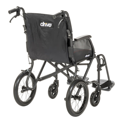 Rear angled view of the AeroFly transport wheelchair showing its black backrest, caregiver handles, and cross-brace frame.