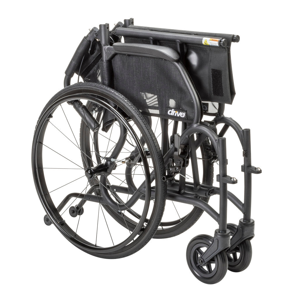 Black AeroFly wheelchair folded for storage and transport, with the backrest lowered and rear wheels attached.