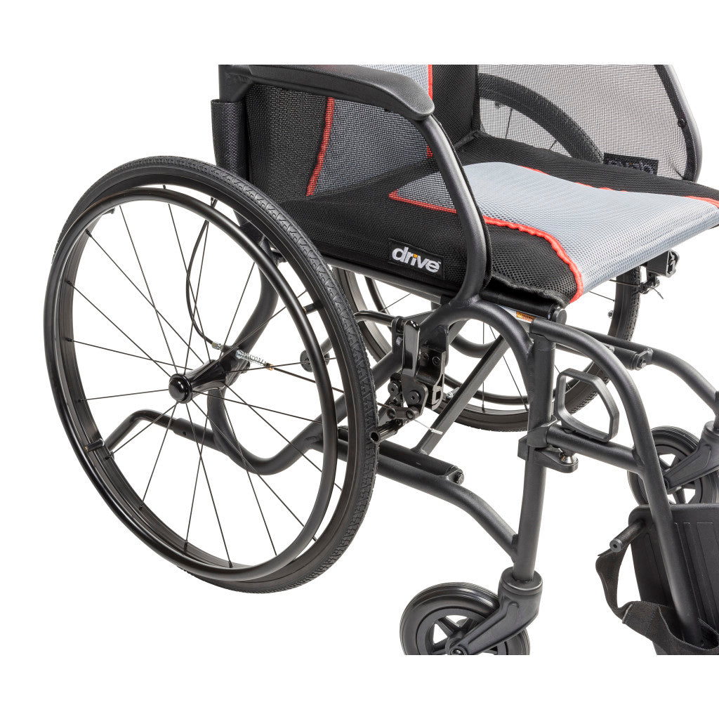 Close-up of the AeroFly wheelchair’s rear wheel, black armrest, and gray seat upholstery with red trim.