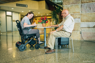 User relaxing in the Pride Jazzy Carbon while traveling through the airport.