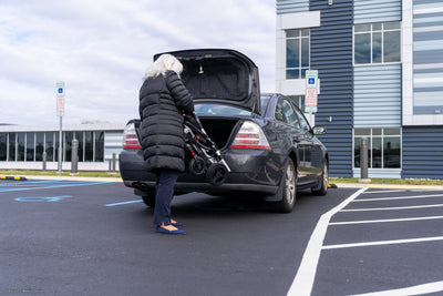 Folded Pride Jazzy Carbon being stored inside a sedan trunk.