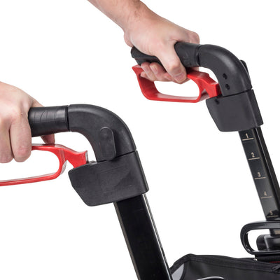 Hands holding the Drive Nitro rollator’s ergonomic grips and demonstrating the red hand brake levers.