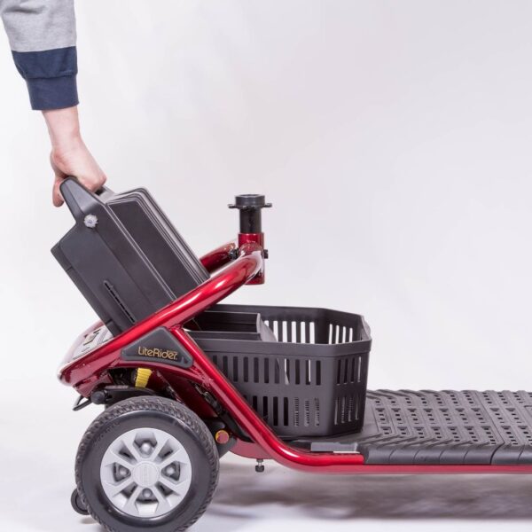 Golden LiteRider scooter battery pack being lifted out by its built-in handle for convenient charging and transport.